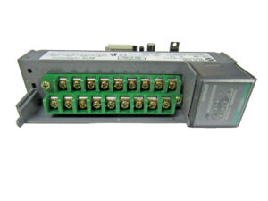 Grey PLC on its side displaying a green plastic wire connector.